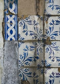 an old blue and white tile design on the side of a building with peeling paint