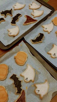 four trays filled with decorated cookies on top of a table