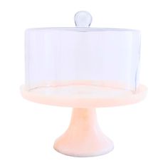 a white cake stand with a clear cover on it's top and an object in the middle