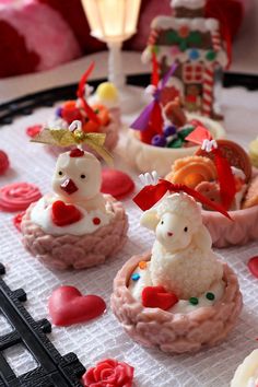 some small food items are sitting on a table with hearts and candles in the background