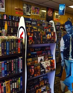 there is a man that is standing in front of a book shelf with books on it