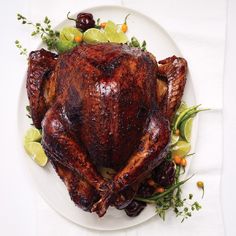 a roasted turkey on a white plate with garnish