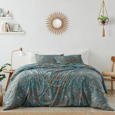 a bed in a room with a blue comforter and pillows on the floor next to a chair