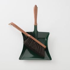 a green shovel and brush on a white background