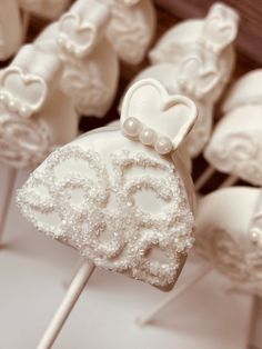 wedding cake pops with white frosting and bowknots on them are ready to be eaten