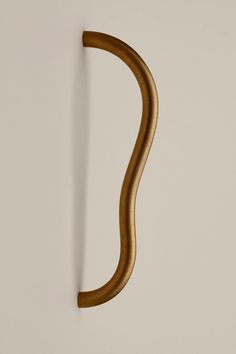 a curved wooden handle on a white wall