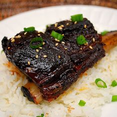 a white plate topped with rice and meat on top of it's side dish