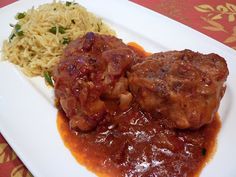 two meatballs and rice on a white plate