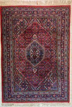 an antique persian rug is displayed on the floor