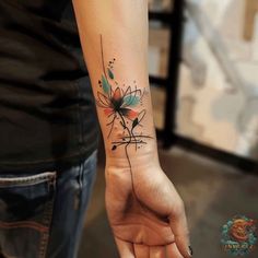 a woman's arm with a flower tattoo on the left side of her hand