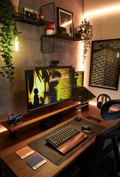 a computer desk with a keyboard, mouse and monitor on it in front of a plant