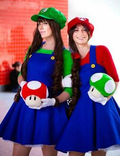 two women dressed as mario and luigi are standing next to each other with their hands in their pockets