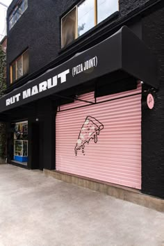 a pink and black building with graffiti on it