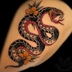 a snake tattoo with flowers on it