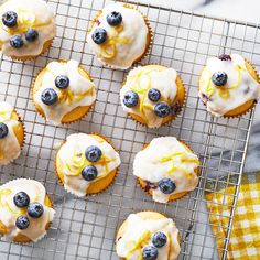 blueberry cupcakes with lemon drizzled on top are cooling on a wire rack