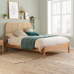 a bed sitting in a bedroom next to a wooden dresser and window with potted plants on it