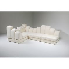 a white sectional sofa sitting on top of a white floor