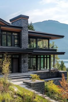 a large house with lots of windows on the side of it and mountains in the background