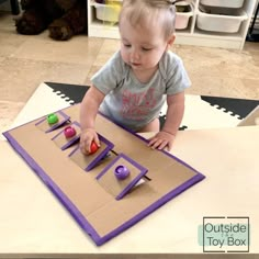 a toddler playing with toys on the floor in front of a play mat that has letters cut out