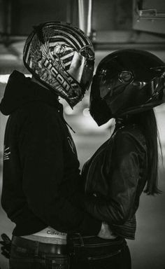 two people wearing helmets standing next to each other