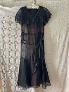 Vintage 1920s/1930s Black Sheer Dress. Flutter cape like detail at top. Smocking detail at drop waist with tie. Flutter handkerchief hem.  Measurements:  Pit to Pit: 18" Length: 47" Waist: 16" Top of Shoulder to Waist:15.5" Neck Opening: 8"  Sold as is, vintage pre-worn condition. Great condition, some small discolored spots. See images More Vintage: https://www.etsy.com/shop/WithEASEvintage Whimsical Maximalist, Hankerchief Dress, 20s Dress, Eclectic Outfits, Dress One Piece, Black Sheer Dress, Vintage Party Dresses, Ren Fair, Drop Waist Dress