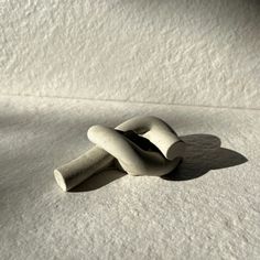 two pieces of concrete sitting on top of a white surface with shadows coming from them