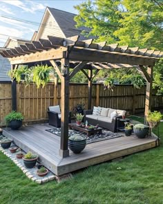 an outdoor living area with couches, tables and potted plants on the deck