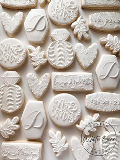 some cookies are decorated with white icing and leaves on them, all in the shape of hearts