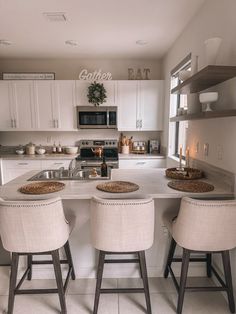 three stools sit at the center of a kitchen island