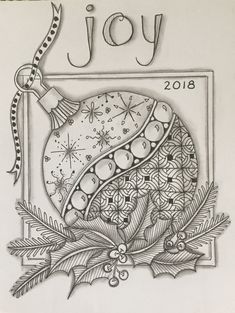 a christmas ornament with the word joy on it and holly leaves around it