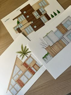 three drawings of houses on top of a table