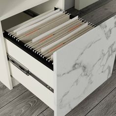 an open file cabinet filled with files on top of a wooden floor