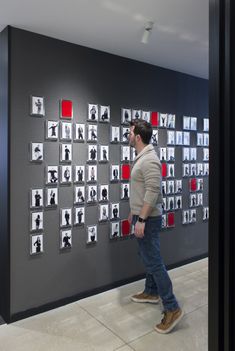 a man standing in front of a wall with pictures on it