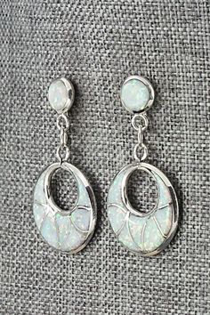 These opalite and sterling silver inlay earrings were made by Zuni silversmith Delorna Lahi. The backs are signed DL.Length: 1 1/2"Width: 3/4"Free shipping on all orders! We ship with USPS and always include tracking. All orders ship within a day of payment.Returns are accepted up to 30 days after you receive your order. Just send us a message. Our shop offers cash back or store credit. The item must be returned in new condition. White Opal Earrings For Pierced Ears, Elegant Drop Earrings With Inlay, Silver Opal Dangle Earrings, Silver Dangle Opal Earrings, White Opal Jewelry With Matching Earrings, Sterling Silver Jewelry With White Inlay, White Sterling Silver Jewelry With Inlay, Silver Opal Dangle Jewelry, White Opal Drop Earrings