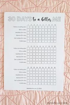 a printable 30 days to a better me calendar on a pink quilted surface