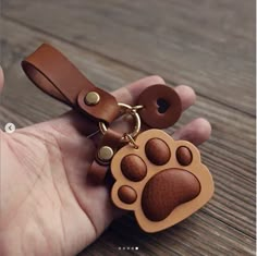 a hand holding a keychain with a dog's paw on the front