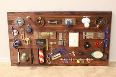 a wooden board with lots of different items attached to it on the floor next to a wall