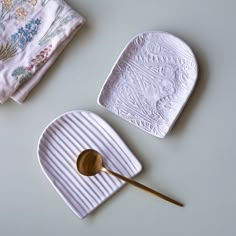 two white dishes with spoons and napkins next to each other