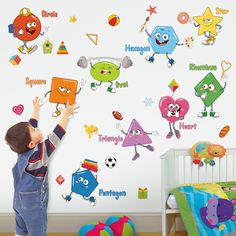 a young boy standing in front of a wall with cartoon stickers on it's walls