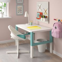 a child's desk and chair in a room with pink walls