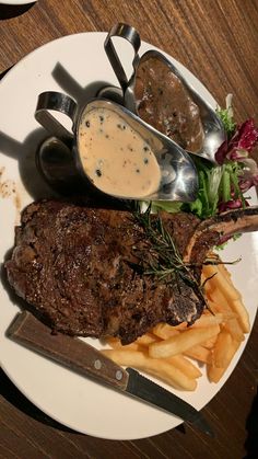 steak, french fries and gravy on a white plate with utensils