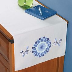 a wooden cabinet with a white table cloth on it and a blue pen resting on top