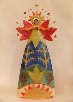 a colorful angel statue with trees and stars on it