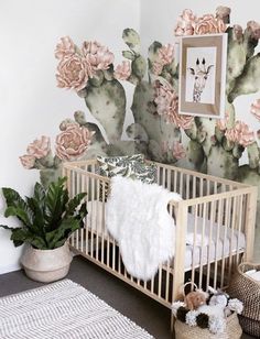 a baby crib in front of a cactus wall mural