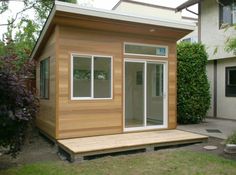 a small wooden house sitting on top of a lush green field