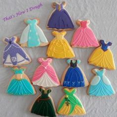 there are many decorated cookies in the shape of princess dresses