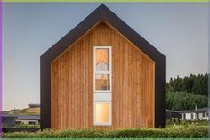 a wooden building with two windows in front of it