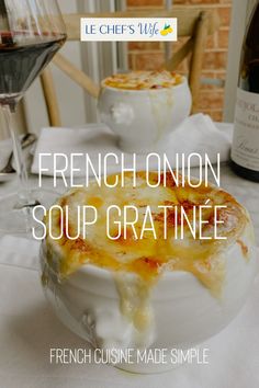 french onion soup gratinne served in a bowl with a glass of wine on the side