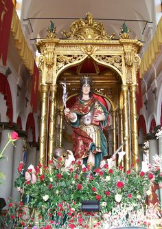 a statue of jesus surrounded by flowers in a church