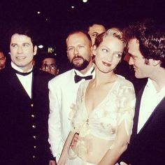 a group of people standing next to each other in tuxedos and bow ties